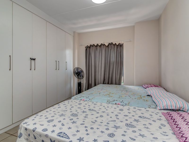 A functional bedroom featuring extensive floor-to-ceiling built-in cupboards providing ample storage space.