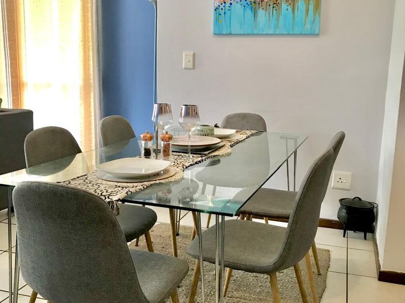 A bright dining area featuring tiled flooring and a curtain rod, providing a functional space for meals.
