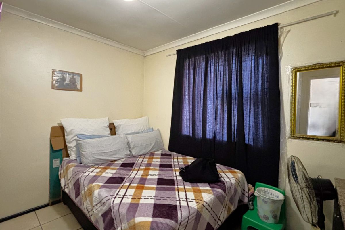 A compact bedroom featuring tiled flooring, a built-in wardrobe, and cove cornicing, offering a functional space ready for cosmetic updates.