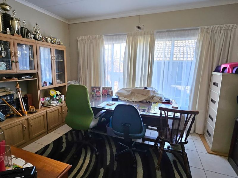 A functional home office space featuring built-in cabinetry and tiled flooring, offering a practical area for work or study.