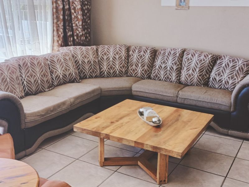 A comfortable living room area featuring tiled flooring and large sliding glass doors that provide natural light.