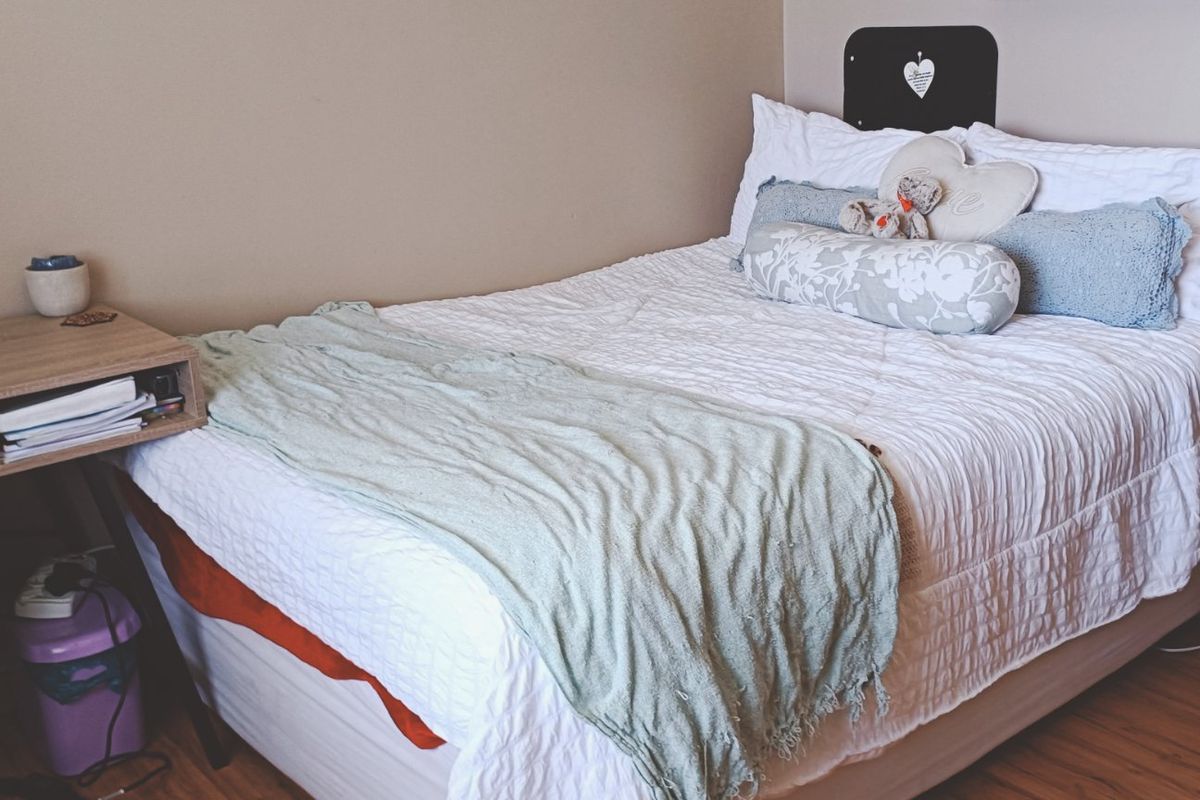 A cozy bedroom featuring laminate flooring and neutral wall tones, providing a comfortable and functional living space.
