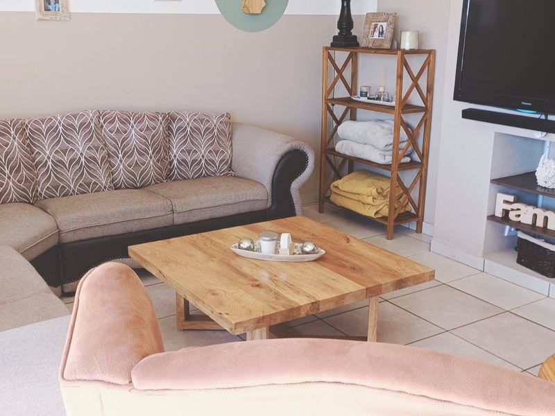 A comfortable living room featuring tiled flooring and a built-in television niche, providing a functional and relaxed space for daily living.