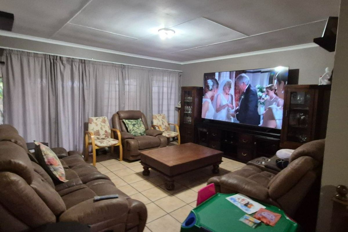 A comfortable living room featuring tiled flooring and neutral wall tones, providing a functional space for relaxation and entertainment.