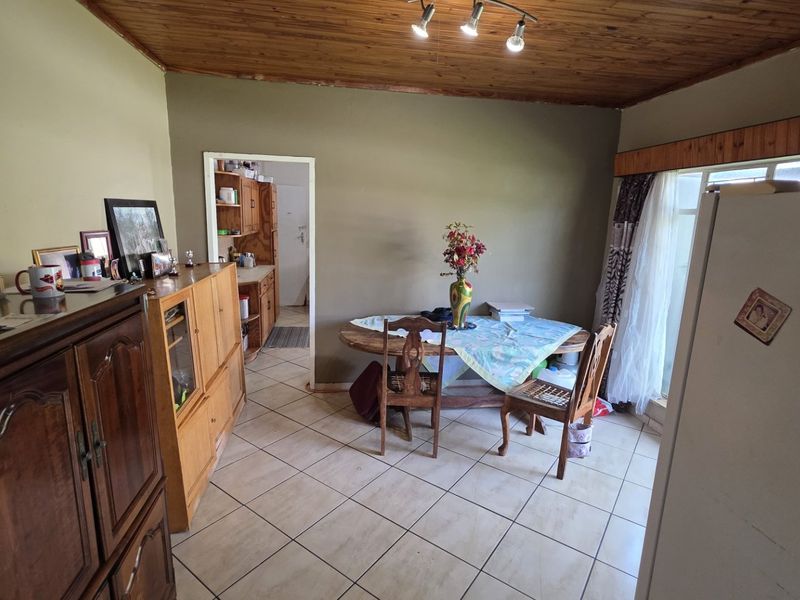 Dining area featuring tiled flooring and a timber-clad ceiling, with direct access to the adjacent kitchen space.