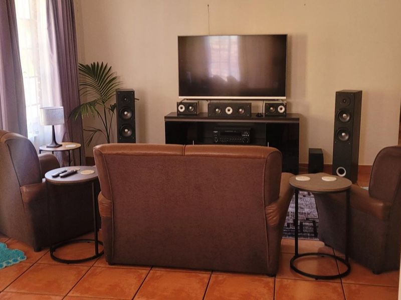 A comfortable living room featuring terracotta floor tiles and neutral wall finishes, providing a functional space for relaxation and entertainment.