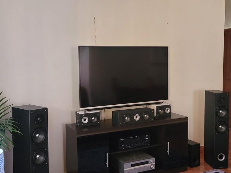 A living room area featuring tiled flooring and neutral wall finishes, providing a functional space for entertainment.