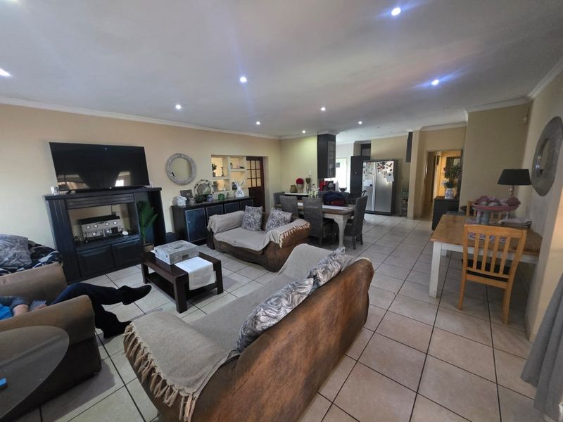 Spacious open-plan living and dining area featuring neutral tiled flooring and recessed downlighting, creating a versatile space for family living and entertaining.