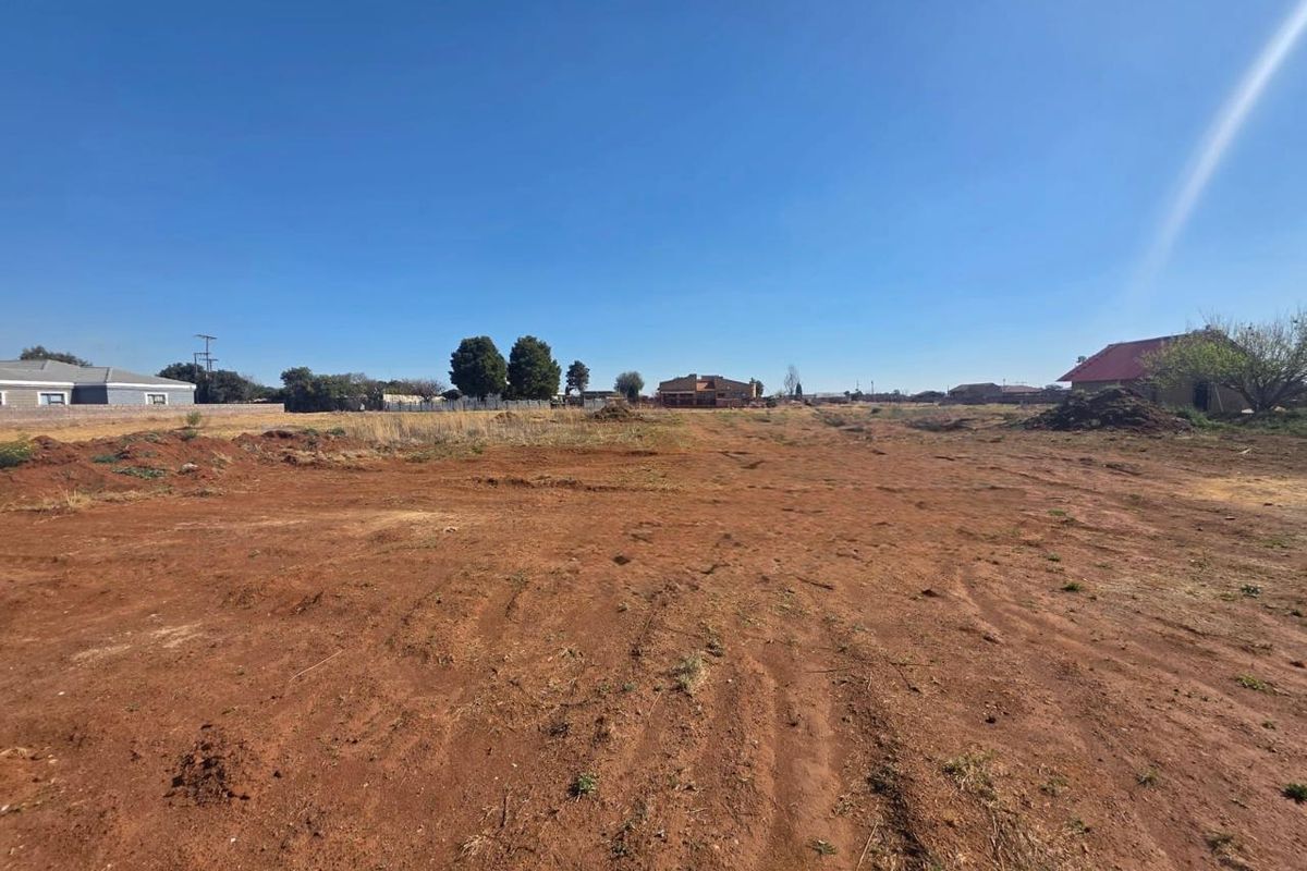 A large, undeveloped plot of land with cleared ground, offering potential for future residential development or landscaping.