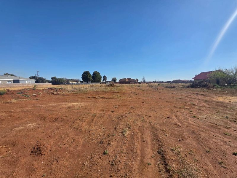 A large, undeveloped plot of land with cleared ground, offering potential for future residential development or landscaping.