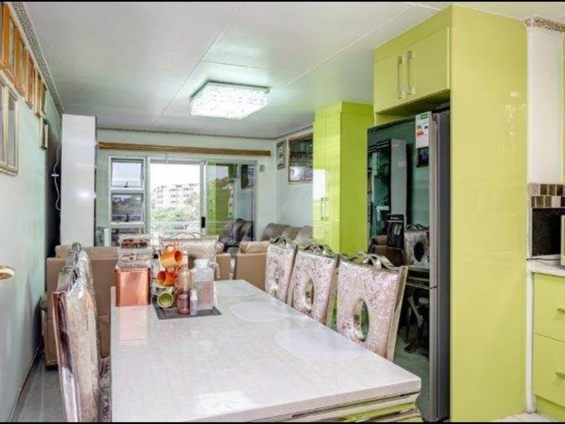 Open plan living and dining area featuring lime green built-in kitchen cabinetry and a sliding glass door leading to an outdoor space.