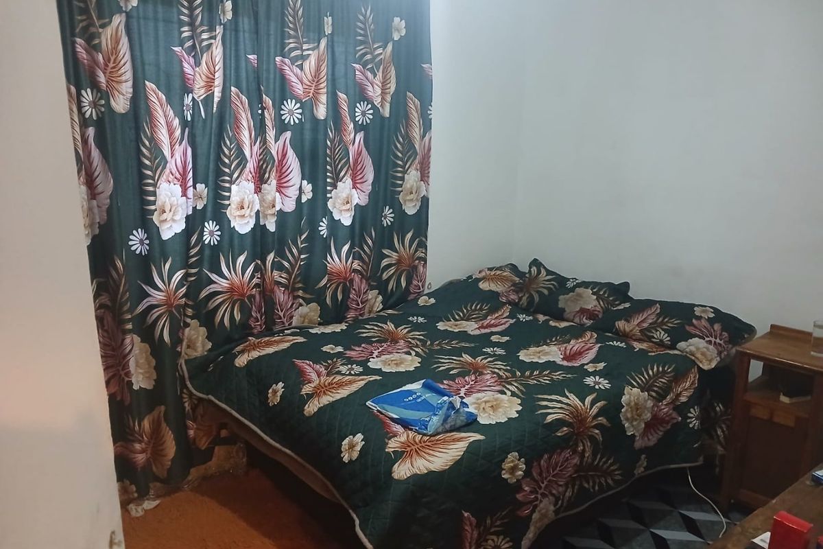 A bedroom featuring standard finishes, currently furnished with a bed and curtains.