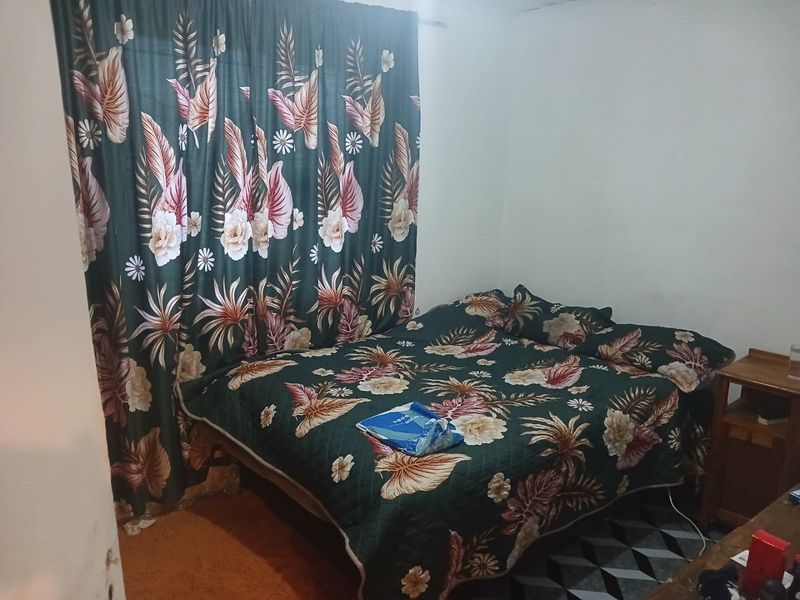 A bedroom featuring standard finishes, currently furnished with a bed and curtains.