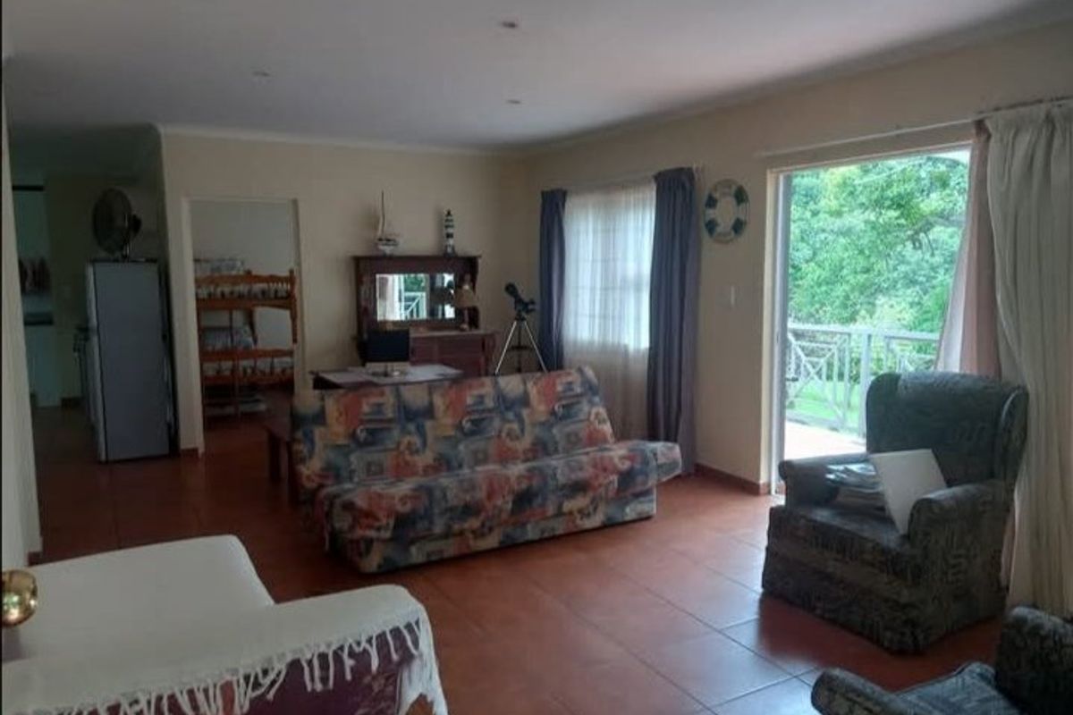 Spacious living room featuring tiled flooring and a large sliding glass door providing access to an outdoor balcony area.