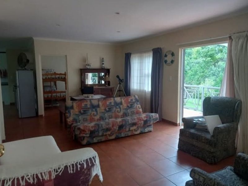 Spacious living room featuring tiled flooring and a large sliding glass door providing access to an outdoor balcony area.