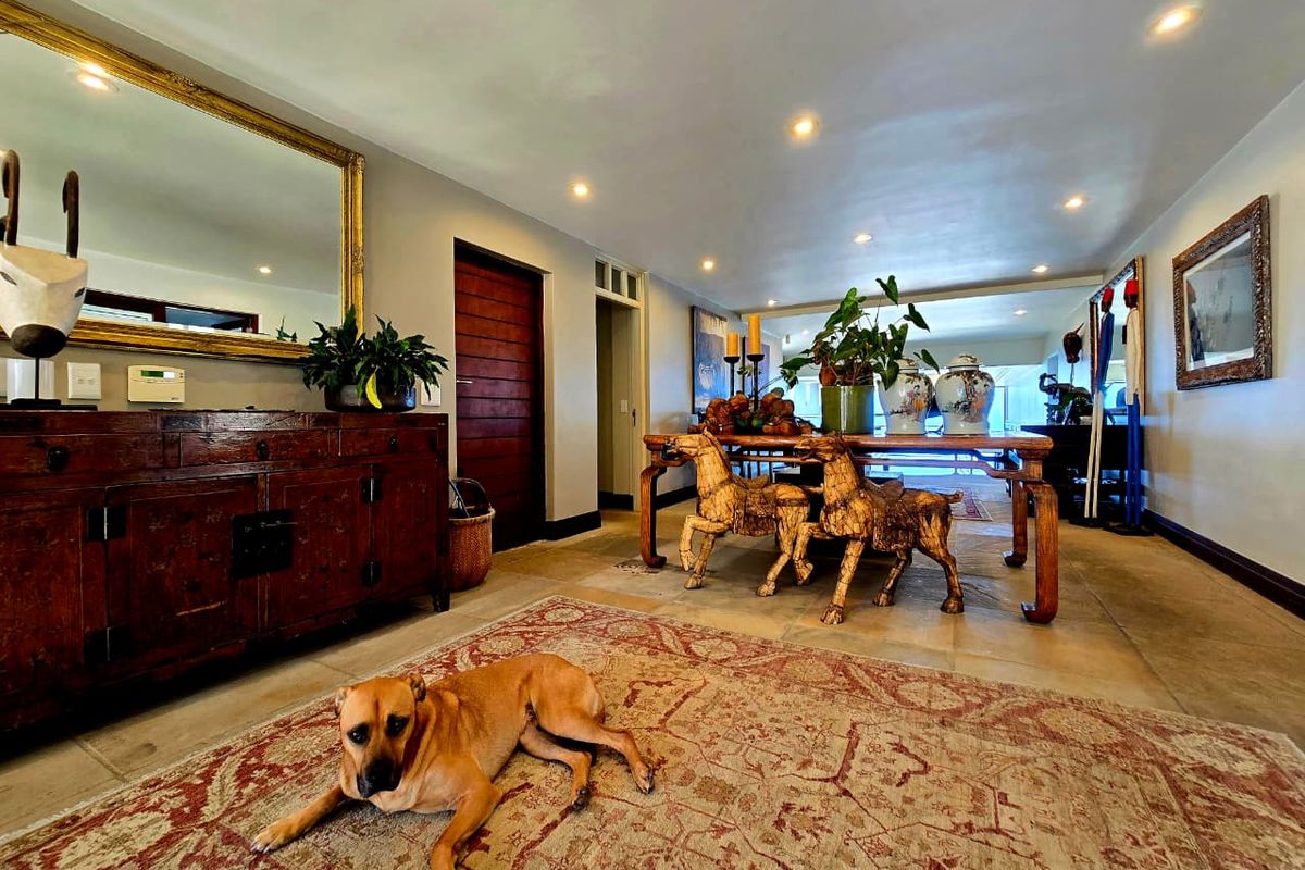 Spacious living area featuring tiled flooring, recessed downlighting, and a solid timber door, offering a neutral and well-maintained interior space.