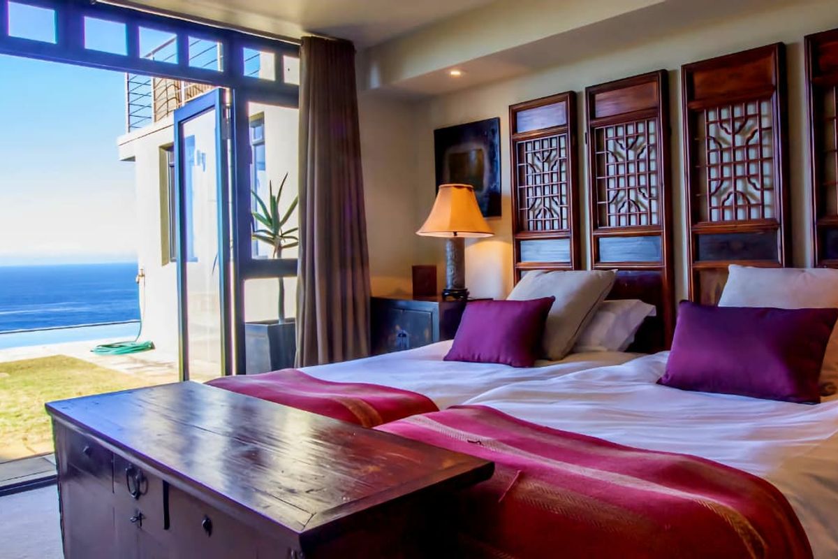 Spacious bedroom featuring large sliding glass doors that open to a patio with expansive ocean views.