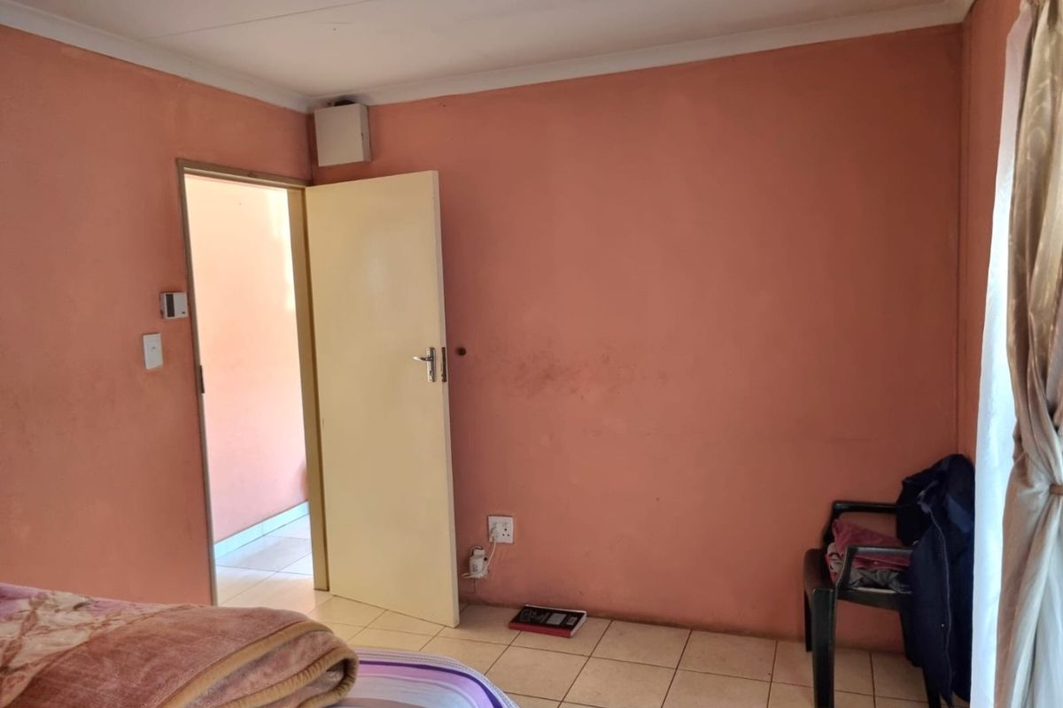 A bedroom featuring tiled flooring and painted walls, requiring cosmetic updates to improve the overall aesthetic and finish.