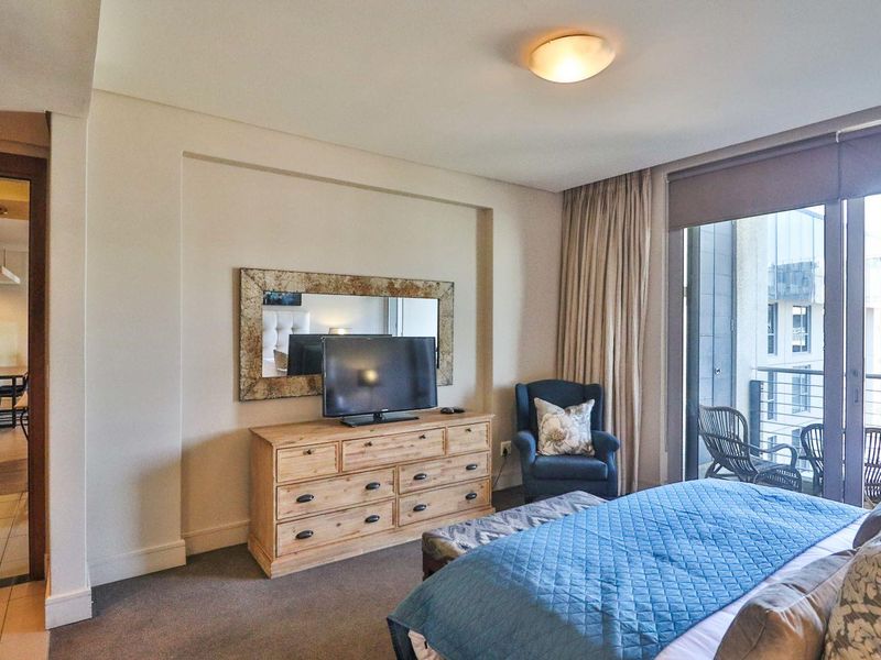 A well-maintained bedroom featuring carpeted flooring, a recessed wall detail, and a large sliding glass door providing access to a private balcony.