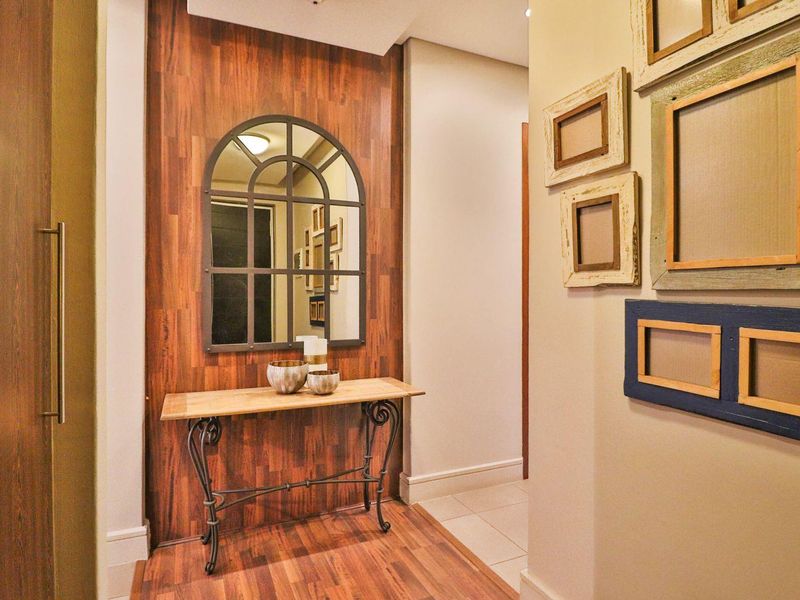 A well-maintained hallway featuring wood-look wall paneling, tiled flooring, and built-in cabinetry, creating a warm and inviting entrance area.
