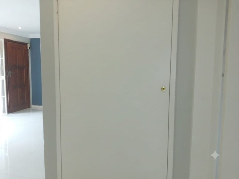A view of a hallway featuring a closed internal door with simple hardware, leading into an adjacent living space.