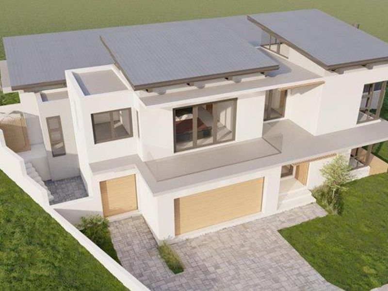 An aerial perspective of a modern residential property featuring a contemporary architectural design, paved driveway, and integrated garage.