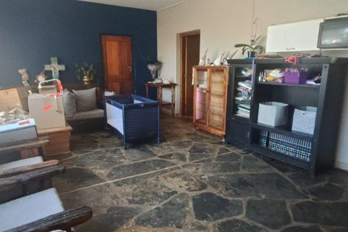 A living room featuring rustic flagstone flooring and a dark blue accent wall, offering a solid foundation for a modern interior update.