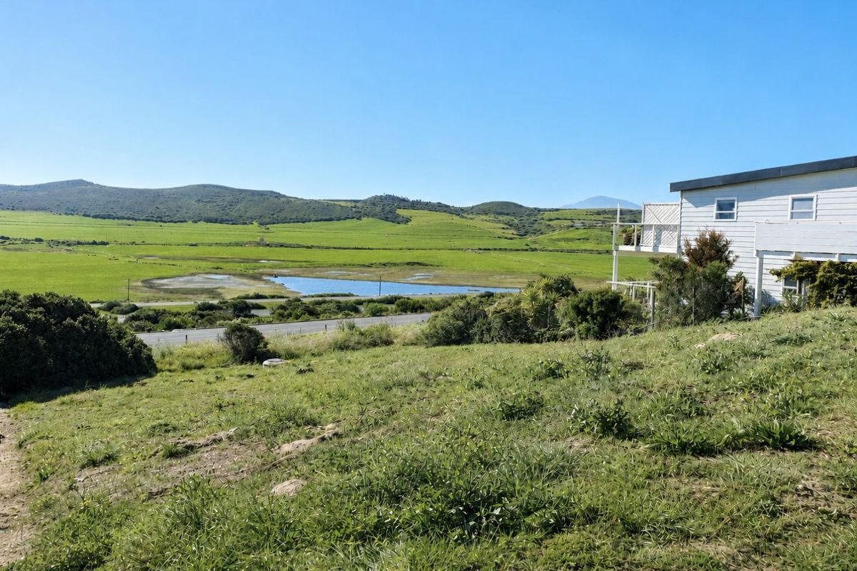 A scenic view overlooking a green valley, wetlands, and distant hills from the elevated residential land.