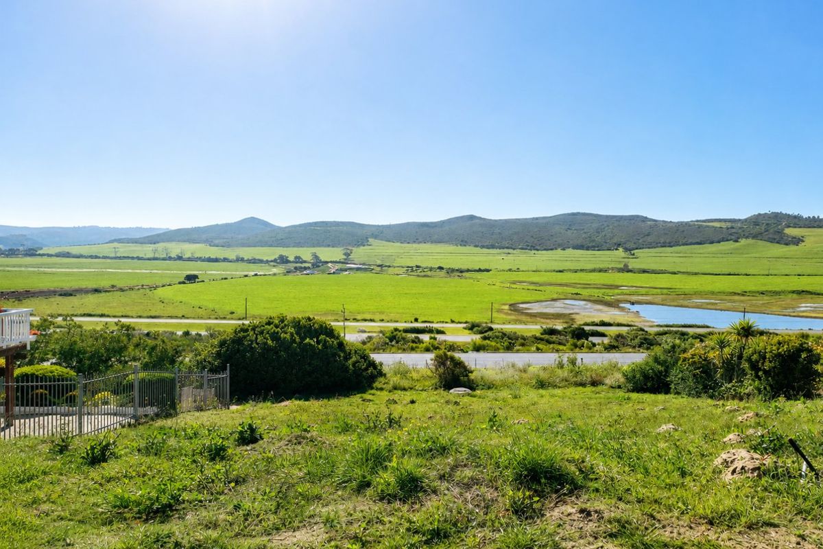 Expansive scenic view overlooking green fields, wetlands, and distant hills from the elevated residential plot.
