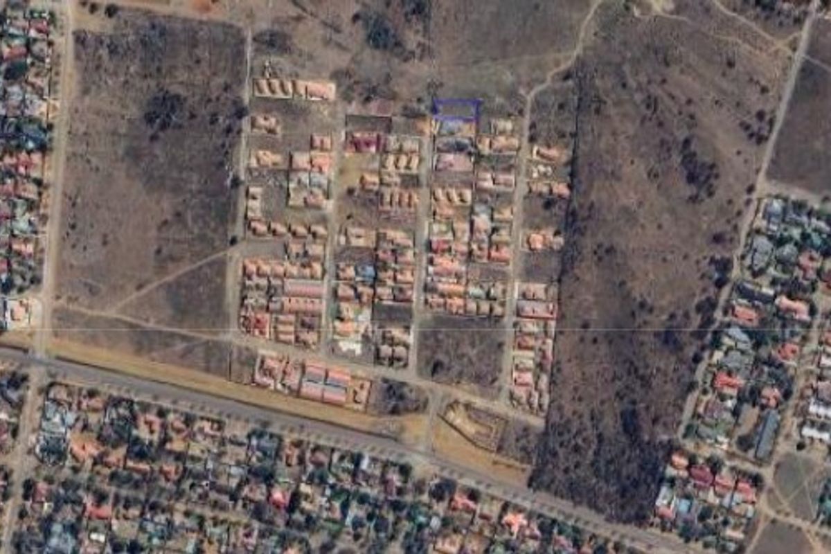 An aerial view of a residential development area showing the layout of plots and surrounding infrastructure.