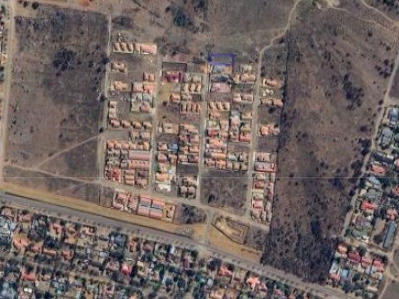An aerial view of a residential development area showing the layout of plots and surrounding infrastructure.