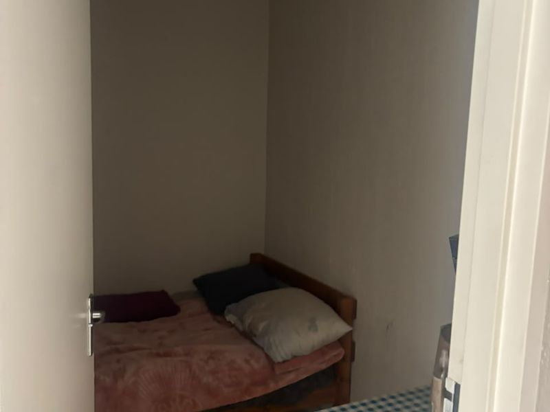A compact bedroom space with neutral wall finishes, suitable for a single bed or small guest room setup.