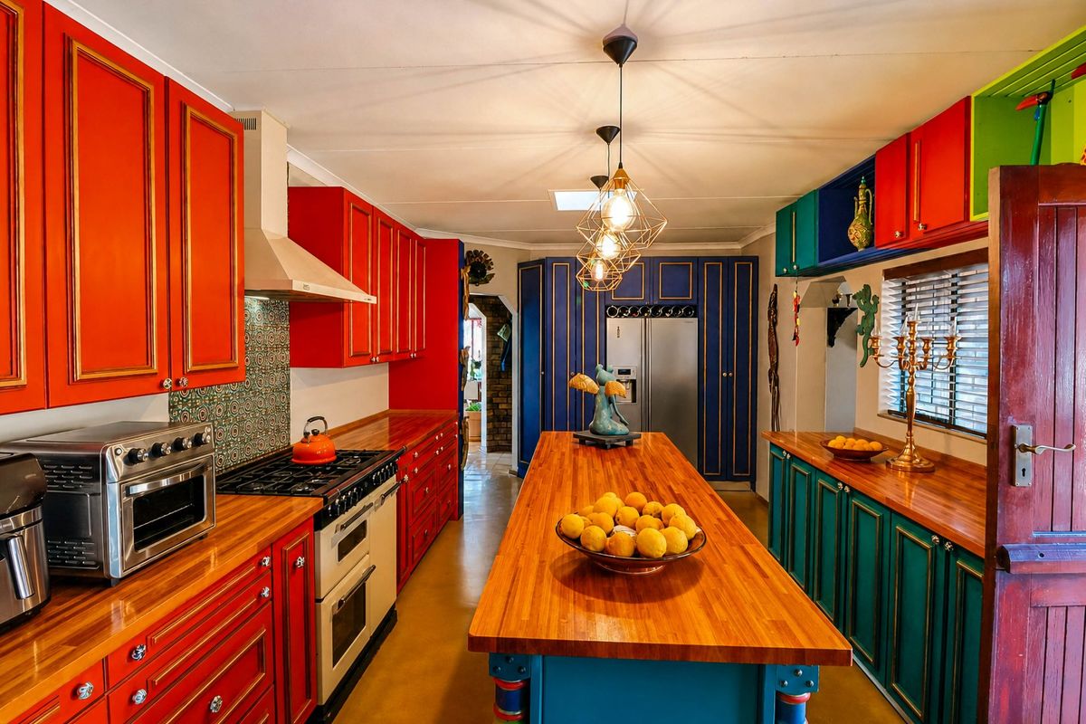 Vibrant kitchen featuring custom multi-colored cabinetry, wooden countertops, a central island, and a gas range with an extractor fan.