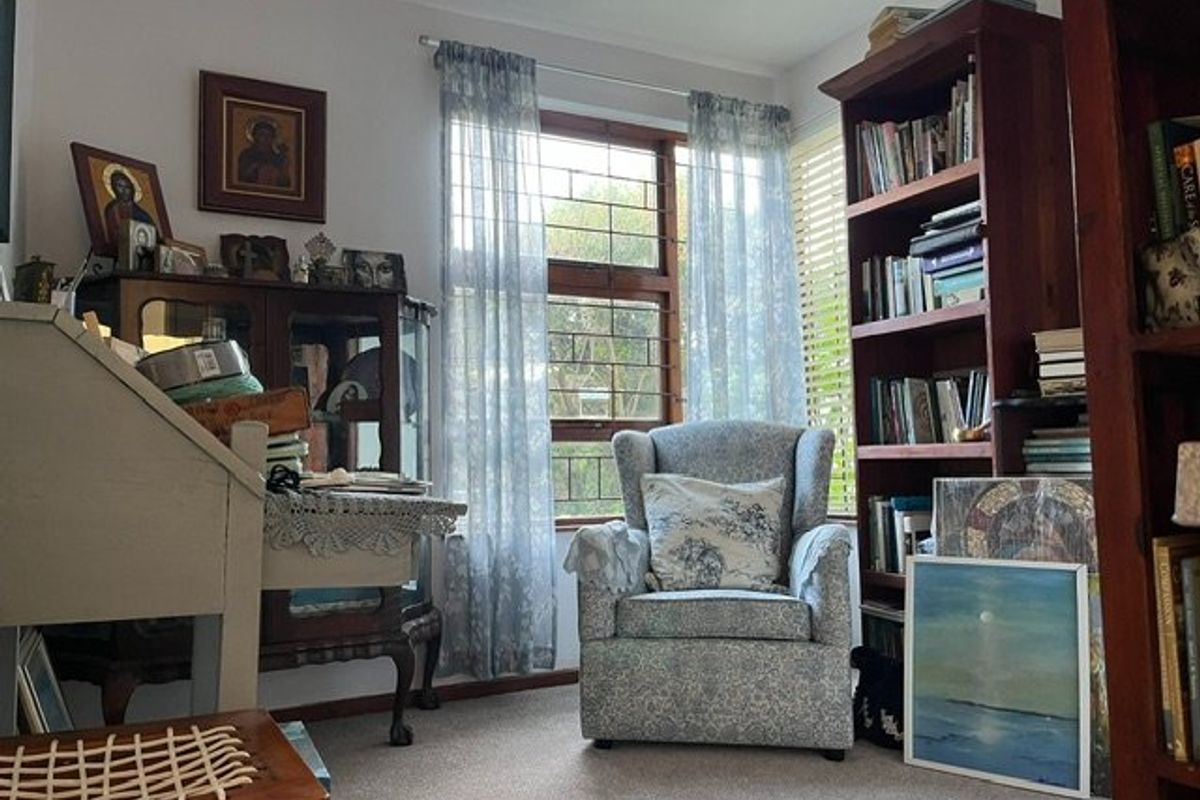 A bedroom featuring carpeted flooring and a window fitted with security bars, providing natural light.