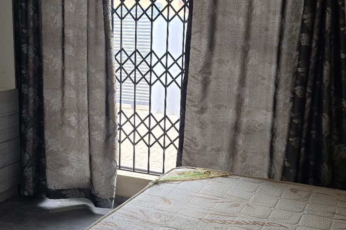 A bedroom featuring a security gate on the window, recessed ceiling lighting, and decorative cornice detailing.