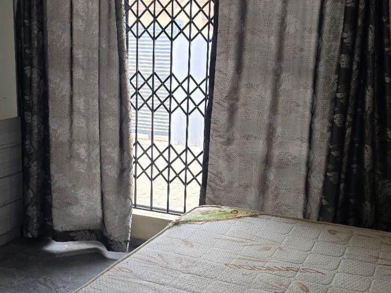 A bedroom featuring a security gate on the window, recessed ceiling lighting, and decorative cornice detailing.