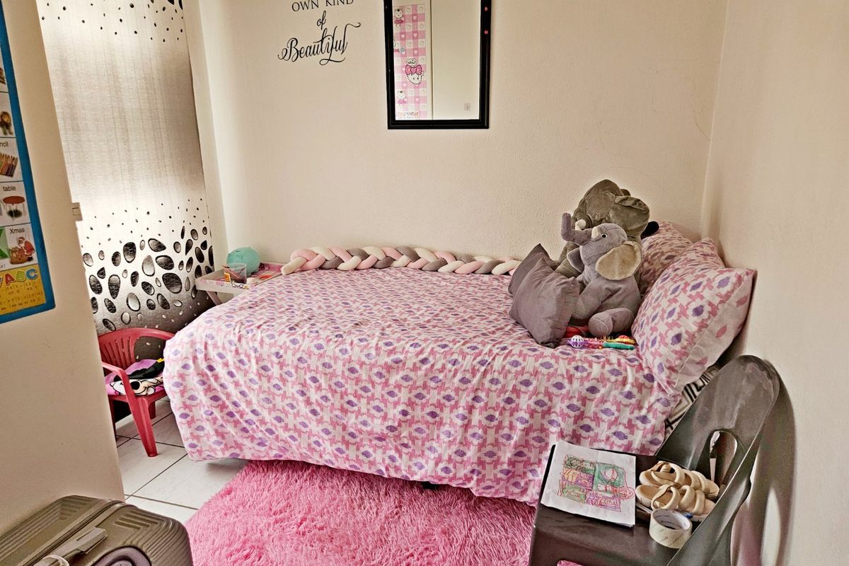 A compact bedroom featuring tiled flooring and a built-in cupboard, providing a functional space for a child or guest.