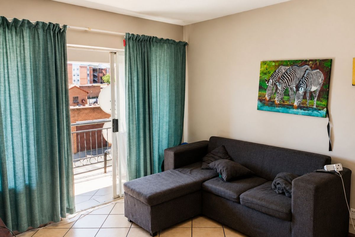 Living room featuring ceramic floor tiles and a sliding glass door providing access to an outdoor balcony area.
