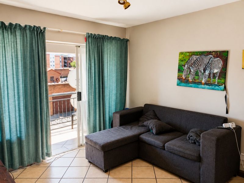 Living room featuring ceramic floor tiles and a sliding glass door providing access to an outdoor balcony area.