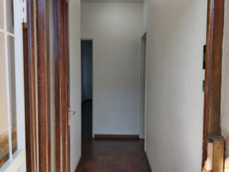 A functional hallway featuring parquet flooring and wooden door frames, providing access to other areas of the apartment.
