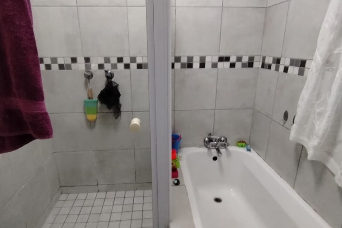 A functional bathroom featuring a separate shower enclosure and a bathtub with tiled walls and flooring.