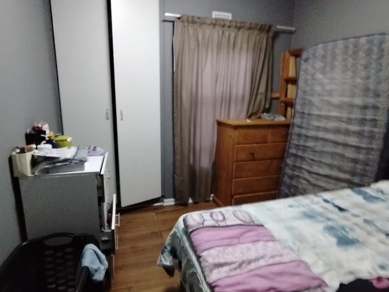 A bedroom featuring laminate flooring and a built-in wardrobe, providing functional storage space within the apartment.