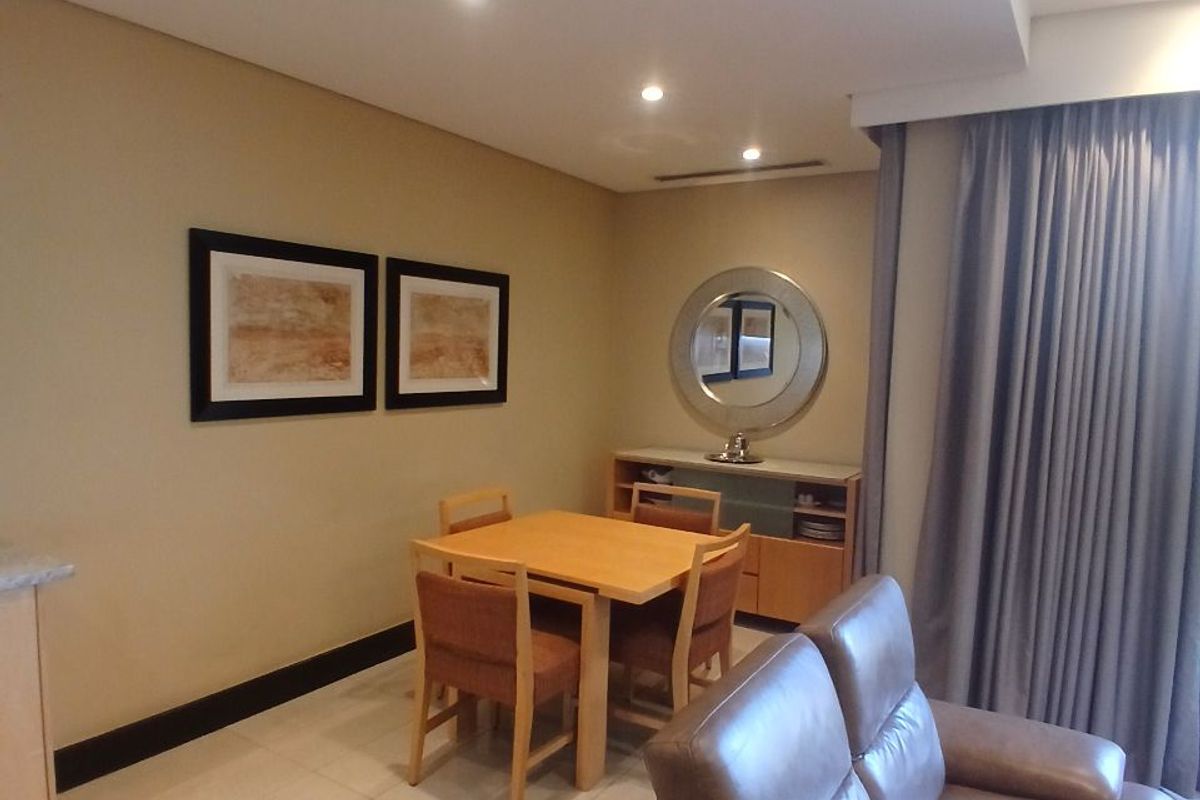 An open-plan living and dining area featuring tiled flooring, recessed downlighting, and neutral wall finishes, creating a functional and cohesive living space.