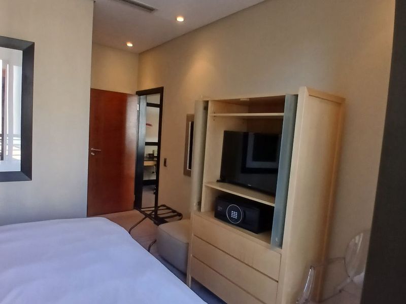 A bedroom featuring recessed lighting and built-in cabinetry with integrated storage and television space.