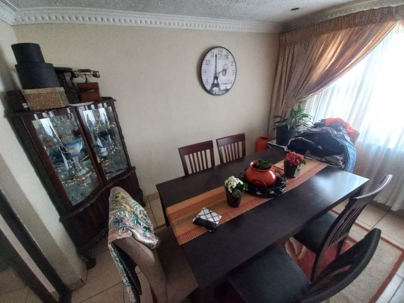 A dining room featuring tiled flooring and decorative ceiling cornicing, providing a functional space for family meals.