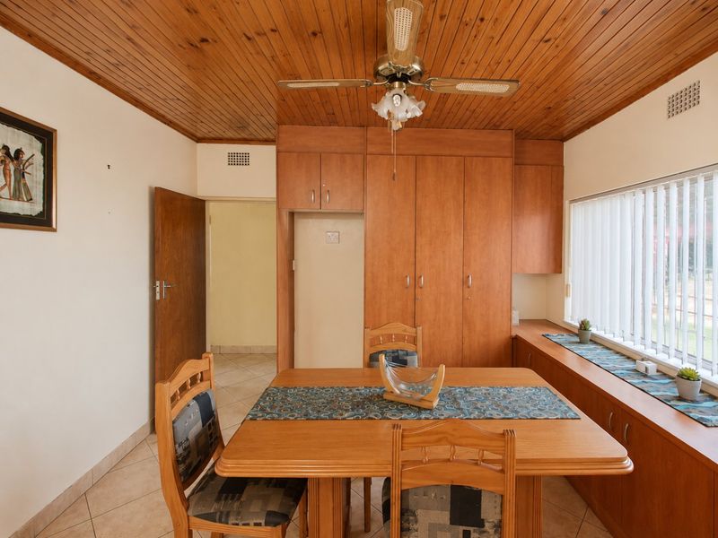 Dining room featuring timber ceiling, ceiling fan, tiled flooring, and extensive built-in cabinetry with integrated storage.