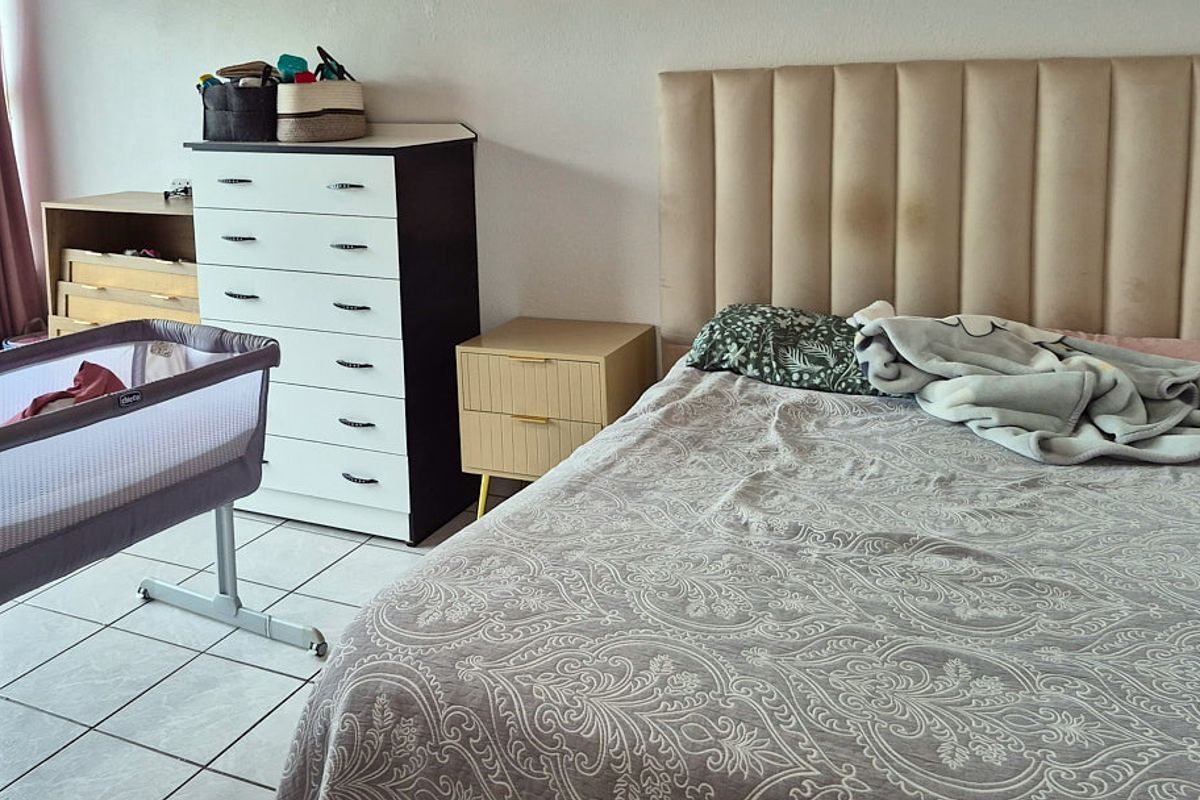 A bedroom featuring tiled flooring and a neutral wall finish, providing a functional space for rest.