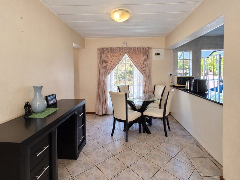 Open plan dining area featuring tiled flooring and a convenient pass-through window connecting to the kitchen space.