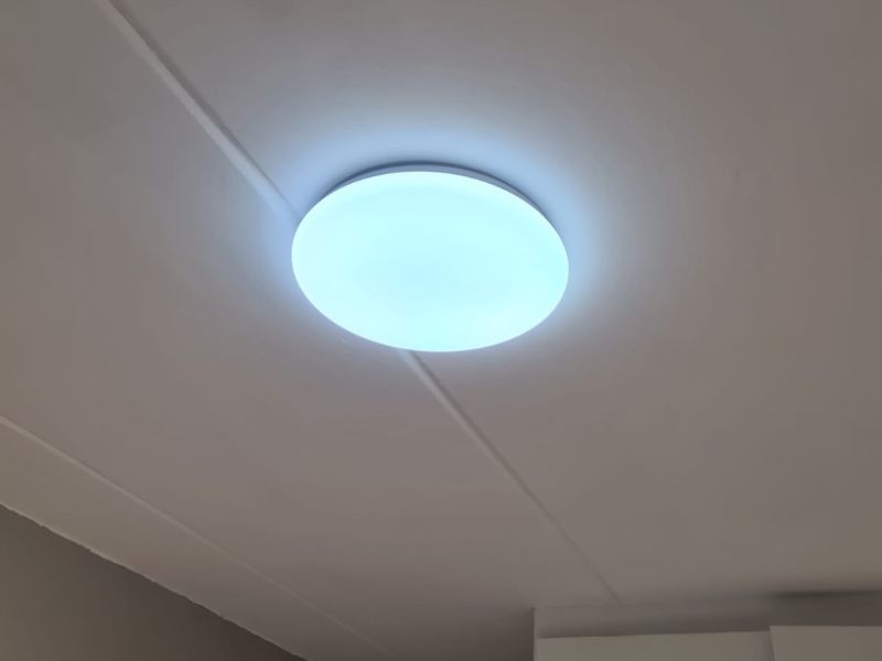 A close-up view of a flush mount ceiling light fixture installed on a white ceiling.