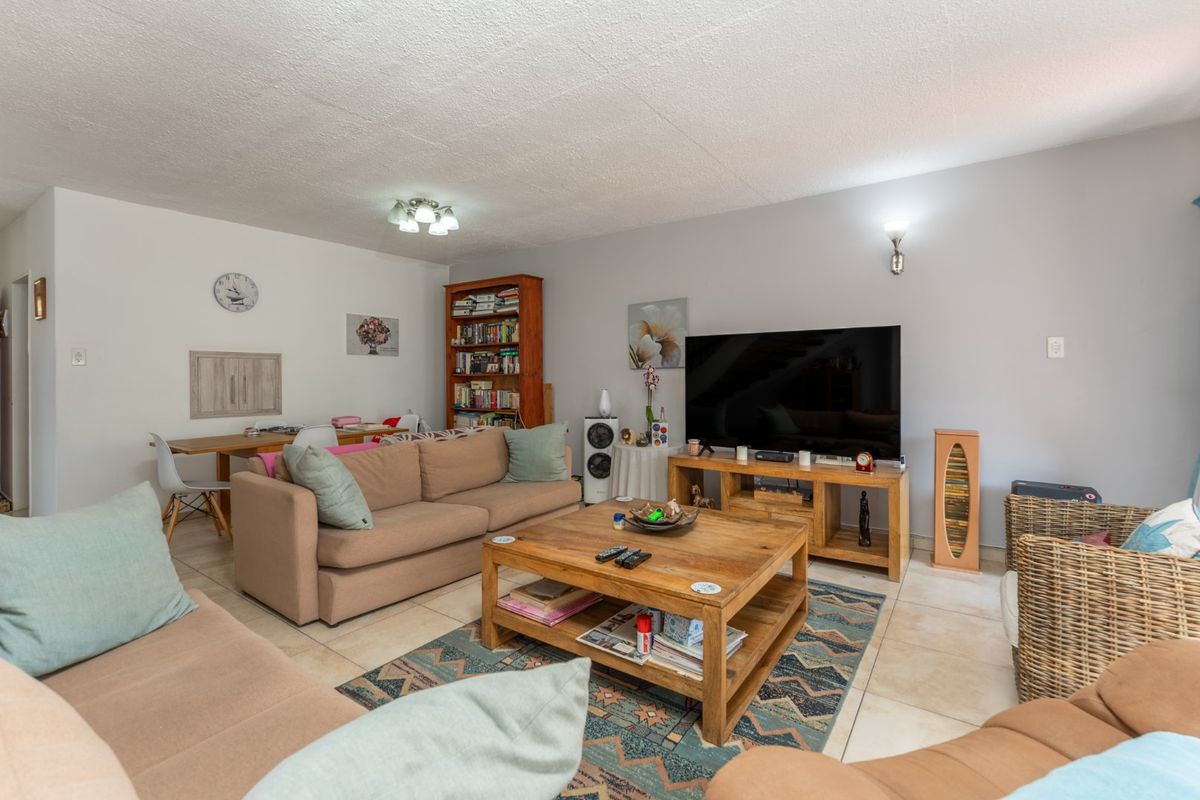 A comfortable living room featuring tiled flooring and neutral wall finishes, providing a functional and inviting space for relaxation.